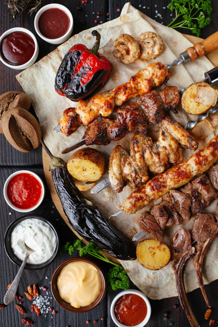 Skewers and vegetables cooking over an open grill